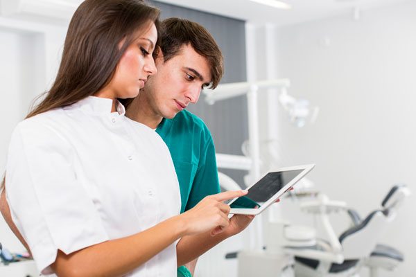 man and woman looking over data in a dental office